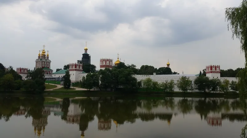 Новодевичий монастырь за прудом, стены и купола отражаются в воде